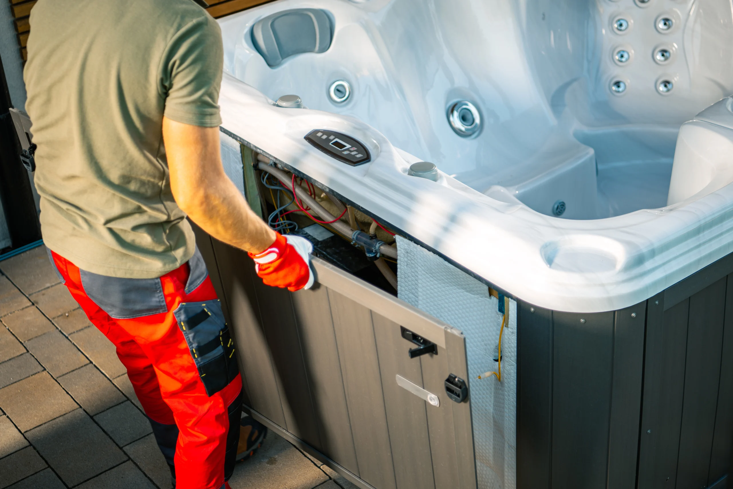 Technician applying specialized insulation seals to a hot tub cabinet to prevent thermal heat loss.